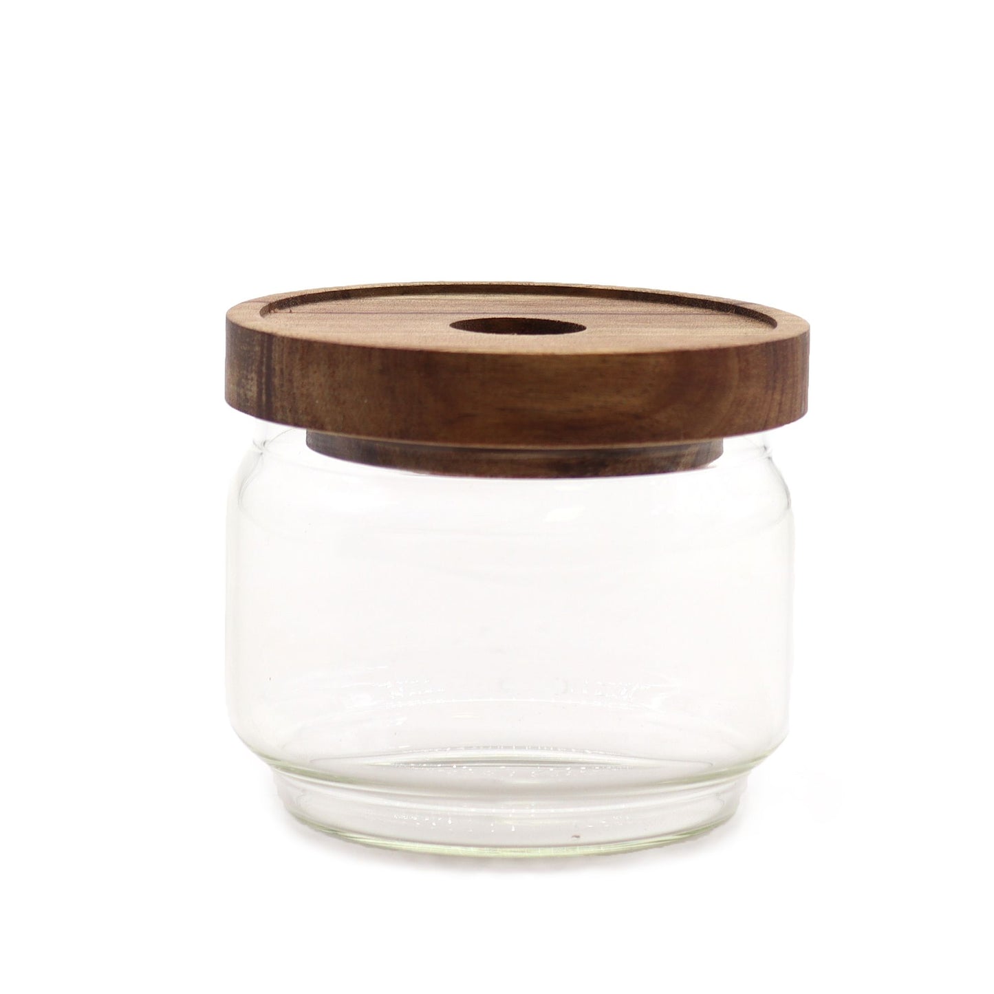 Clear glass jar with a wooden lid on a white background